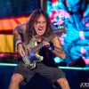 Steve Harris of Iron Maiden performing live on stage with his signature bass guitar and energetic stage presence