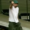 Fred Durst, frontman of Limp Bizkit, performing live on stage in 2003 with microphone, energetic stance, and dramatic stage lighting.