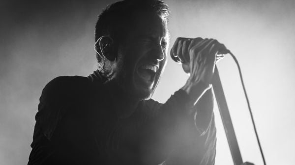 Trent Reznor performing live on stage with Nine Inch Nails during a concert.
