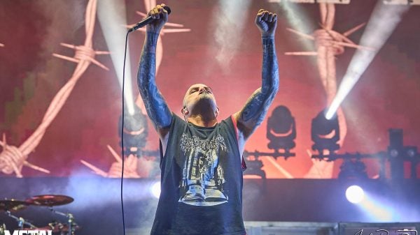 Phil Anselmo, lead vocalist of Pantera, performing live on stage with intense energy and iconic microphone stance
