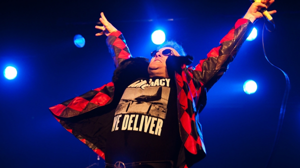 Jello Biafra, punk vocalist and former frontman of Dead Kennedys, performing live on stage with microphone and energetic stage presence