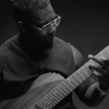 Tosin Abasi, guitarist and founder of Animals as Leaders, playing electric guitar on stage with focused technique